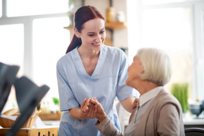 caregiver smiling and talking to aged woman