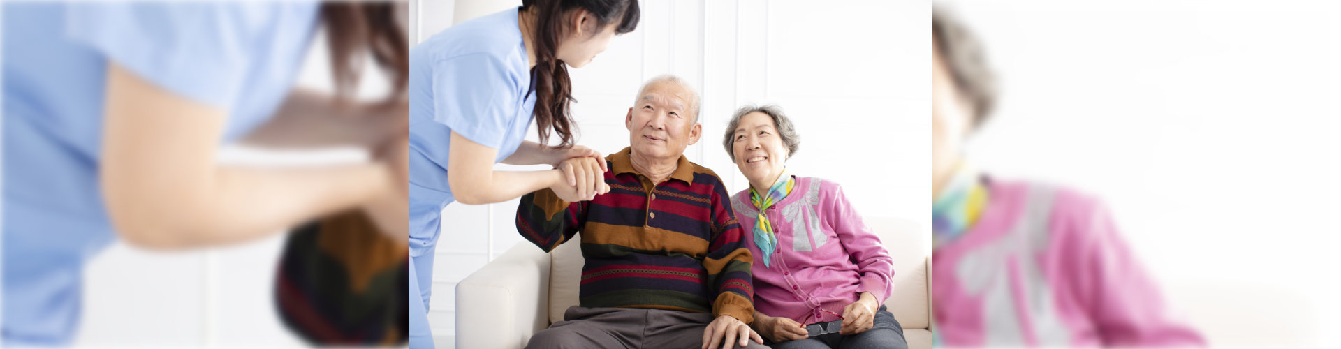 caregiver with senior couple on couch