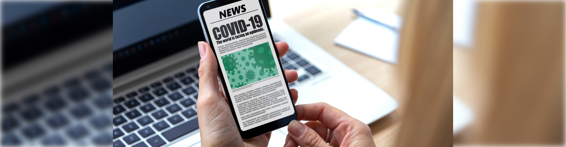 woman holding phone with covid news in display